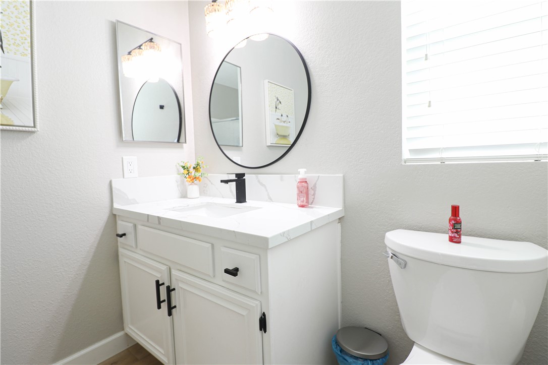 730 Breeze Hill Road, Unit 230 Vista, CA 92081 - Photo 16 of 40 a bathroom with a toilet sink and mirror