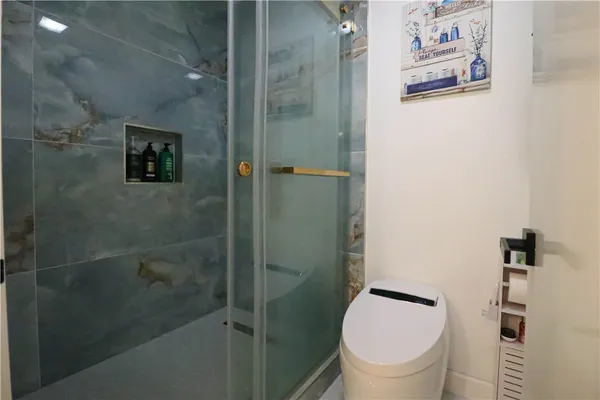 a bathroom with a toilet and a shower
