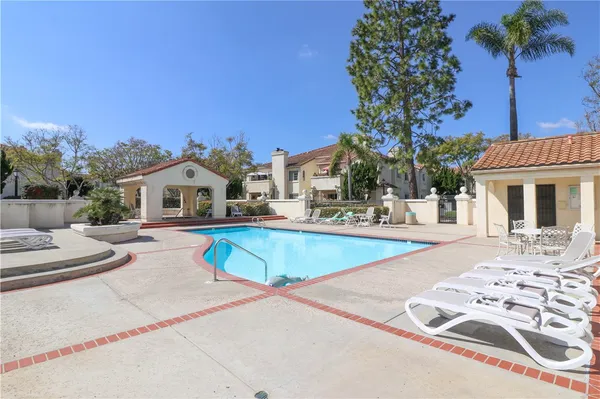 a view of a house with pool and chairs