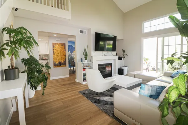 a living room with furniture a flat screen tv and a fireplace