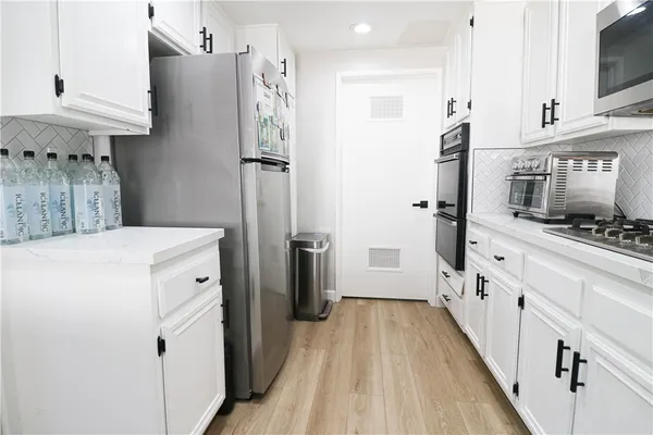 a kitchen with cabinets and a refrigerator