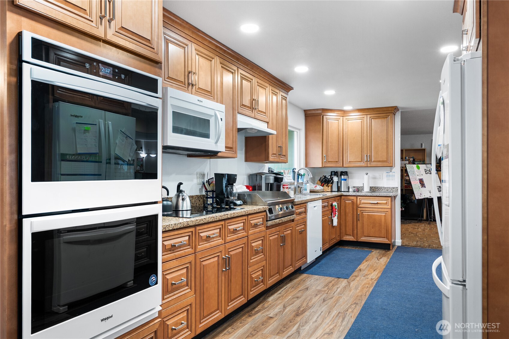 23825 15th Avenue Southeast, Unit 108 Bothell, WA 98021 - Photo 28 of 39 a kitchen with stainless steel appliances kitchen island granite countertop a stove a sink and a refrigerator