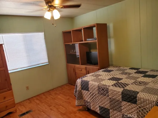 a bedroom with a bed and a ceiling fan