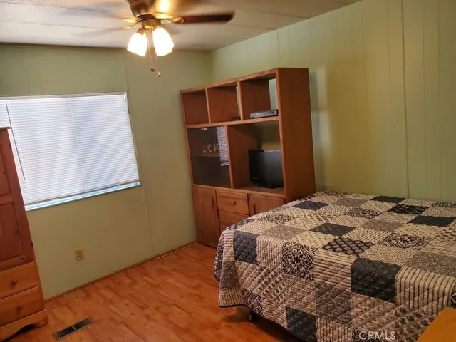a bedroom with a bed and a ceiling fan
