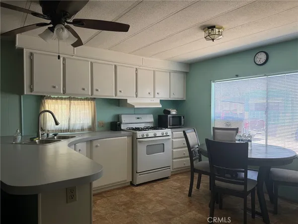 a kitchen with a table chairs and white cabinets