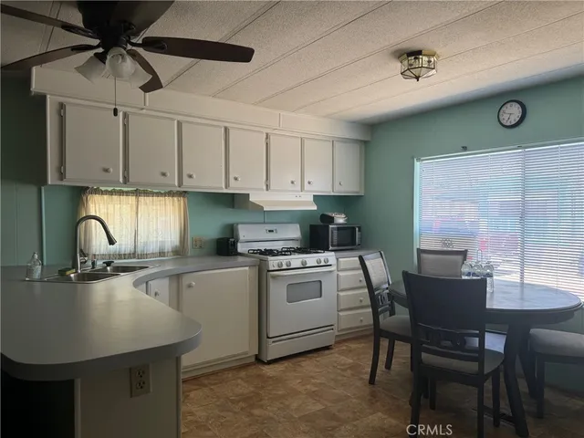a kitchen with a table chairs and white cabinets