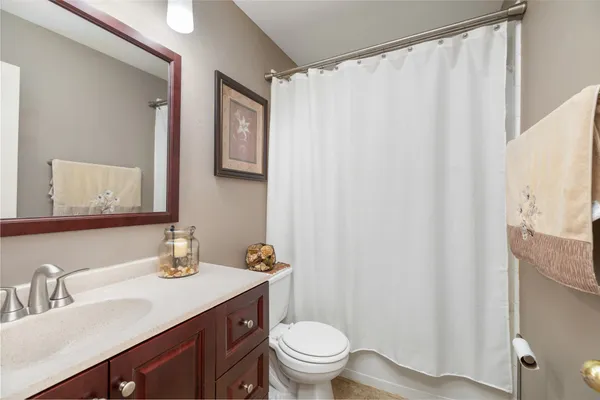 a bathroom with a granite countertop sink toilet and a mirror