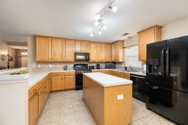 a kitchen with a refrigerator a sink dishwasher a stove top oven a refrigerator and cabinets