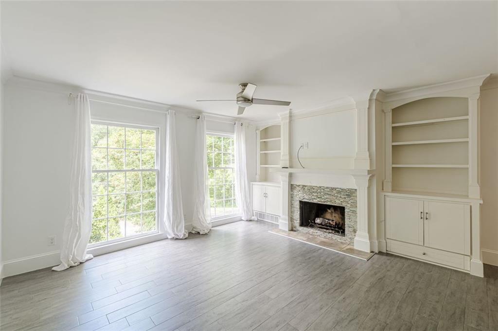 320 Alberta Terrace Northeast, Unit 3 Atlanta, GA 30305 - Photo 27 of 54 an empty room with fireplace wooden floor and windows
