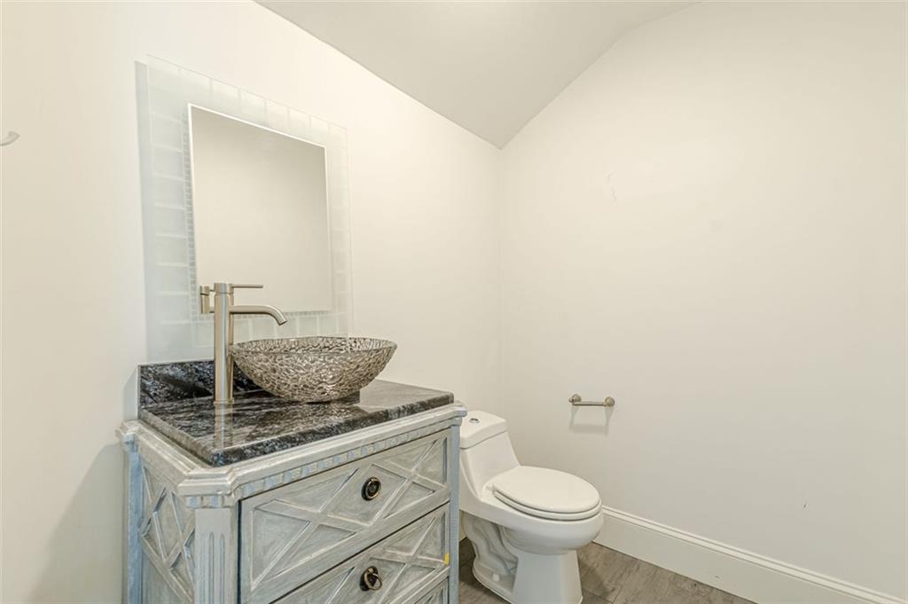 320 Alberta Terrace Northeast, Unit 3 Atlanta, GA 30305 - Photo 28 of 54 a bathroom with a granite countertop toilet and a sink