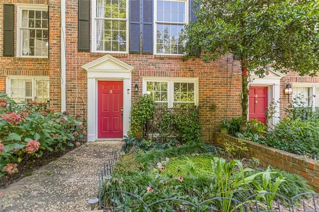 a front view of a house with plants and trees
