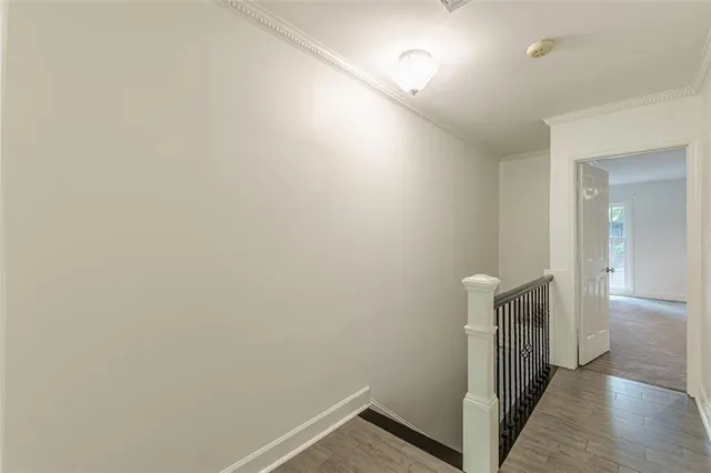 an empty room with wooden floor and ceiling fan
