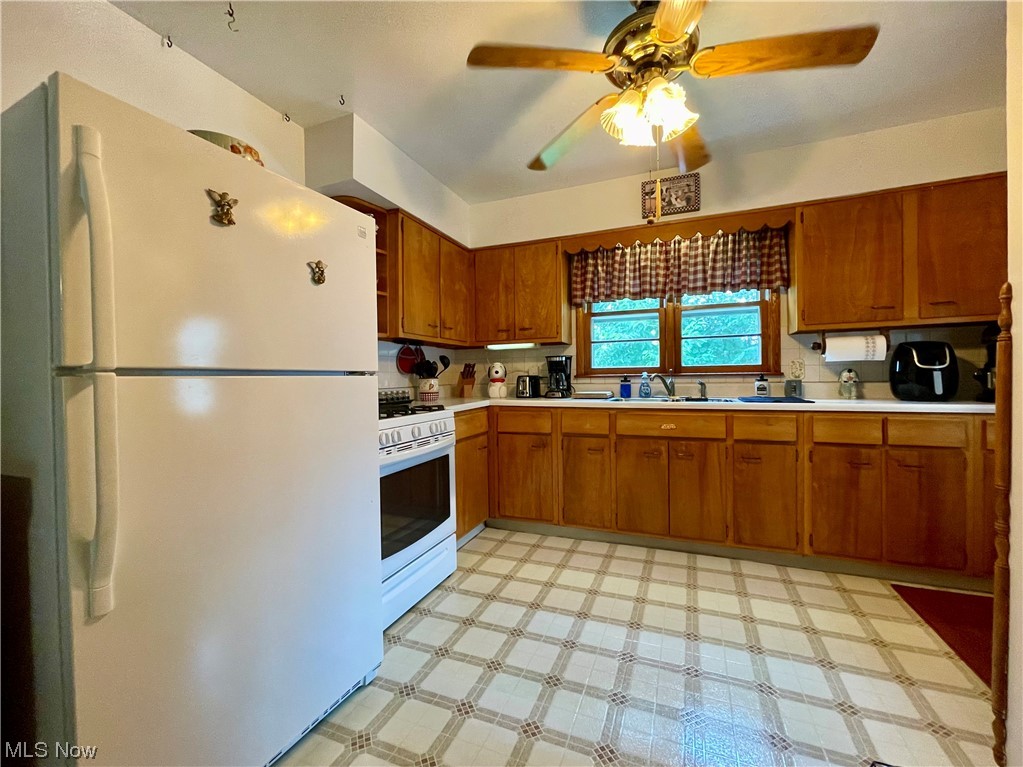 66119 Highway 124 Reedsville, OH 45772 - Photo 16 of 29 Kitchen with brown cabinets, light countertops, light tile floors, ceiling fan, and white appliances