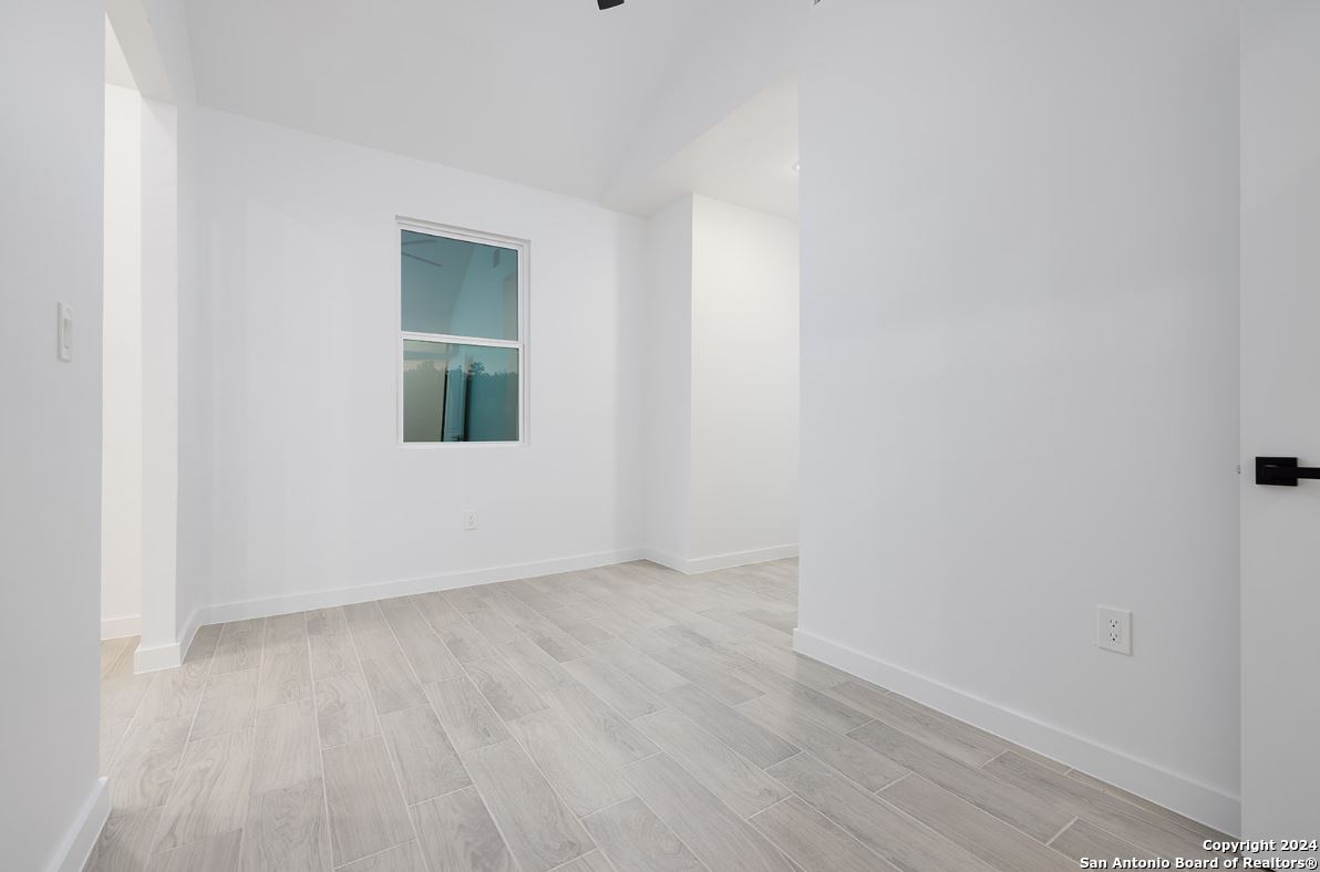 329 Blue Bonnet Breeze Spring Branch, TX 78070 - Photo 11 of 20 a view of an empty room with wooden floor and a window