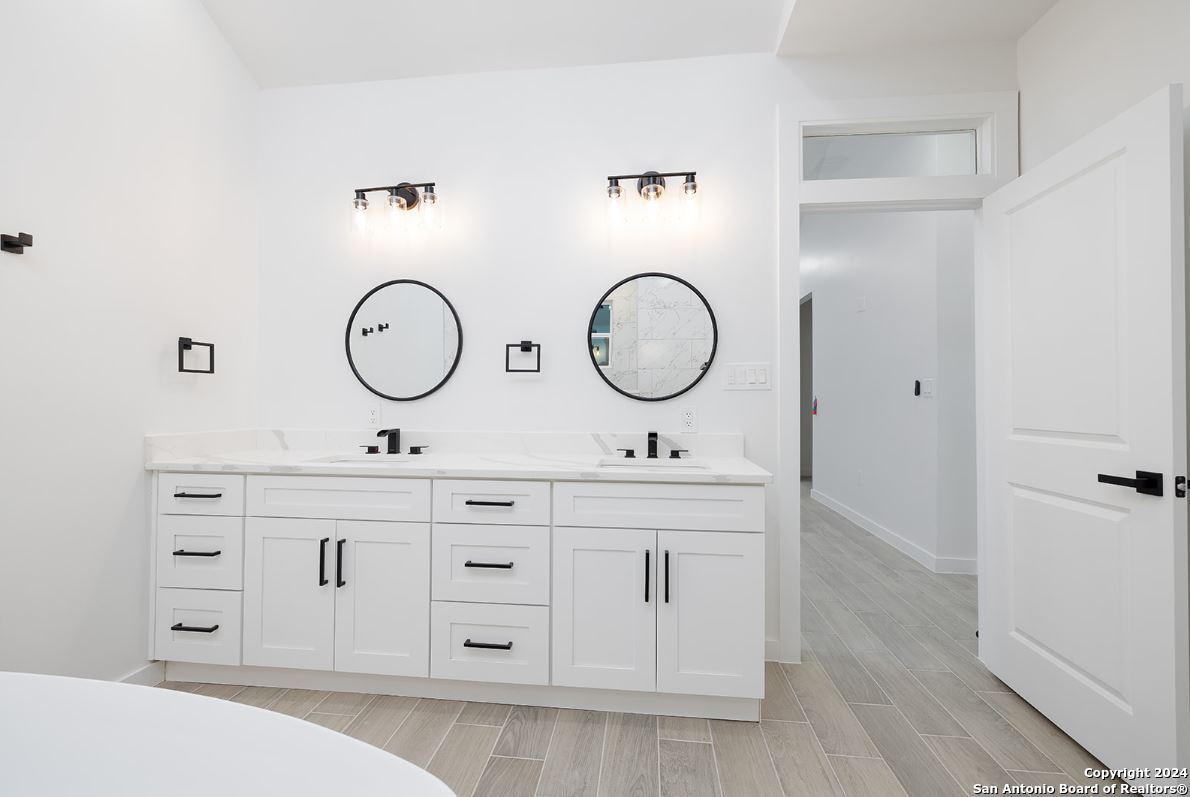 329 Blue Bonnet Breeze Spring Branch, TX 78070 - Photo 12 of 20 a bathroom with a double vanity sink and a mirror