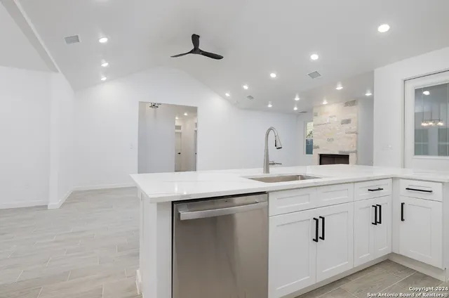 a kitchen with white cabinets appliances and a sink