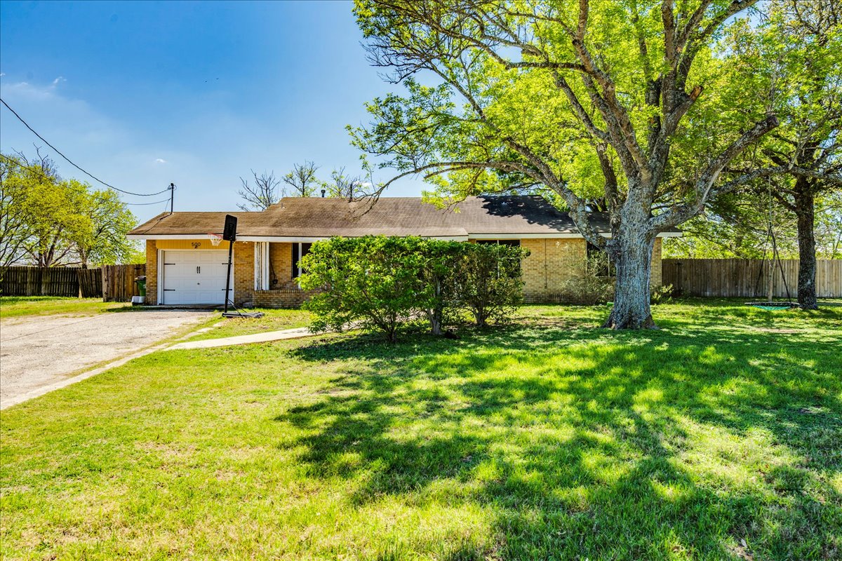 Single story home with brick siding, driveway, and an attached garage