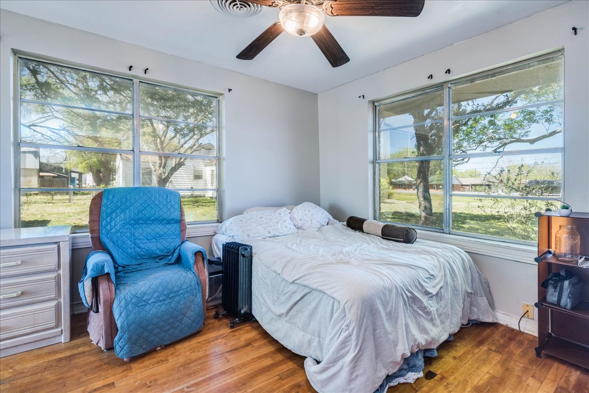 500 Blackjack Street Lockhart, TX 78644 - Photo 13 of 27 Bedroom featuring hardwood / wood-style floors, ceiling fan, and multiple windows