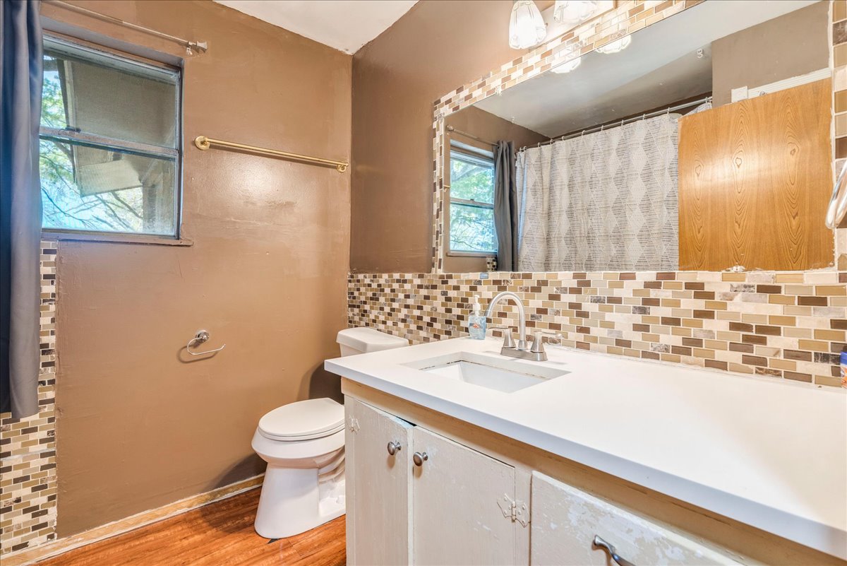 500 Blackjack Street Lockhart, TX 78644 - Photo 19 of 27 Bathroom with vanity, a shower with shower curtain, light wood finished floors, and tasteful backsplash