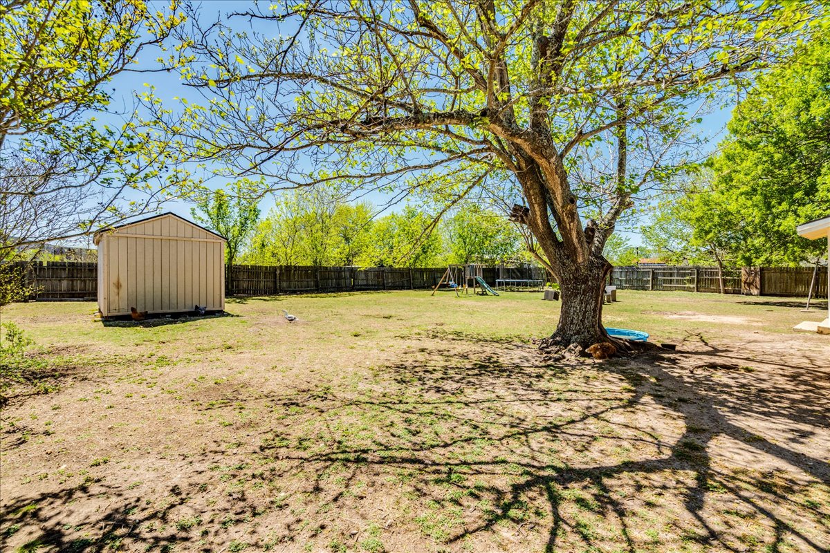500 Blackjack Street Lockhart, TX 78644 - Photo 22 of 27 Fenced backyard with a storage unit