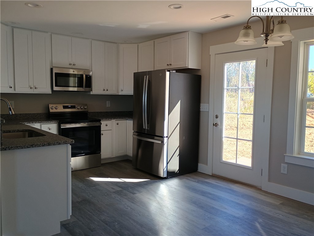130 Millards Way Sparta, NC 28675 - Photo 9 of 12 a kitchen with granite countertop stainless steel appliances a refrigerator microwave and sink