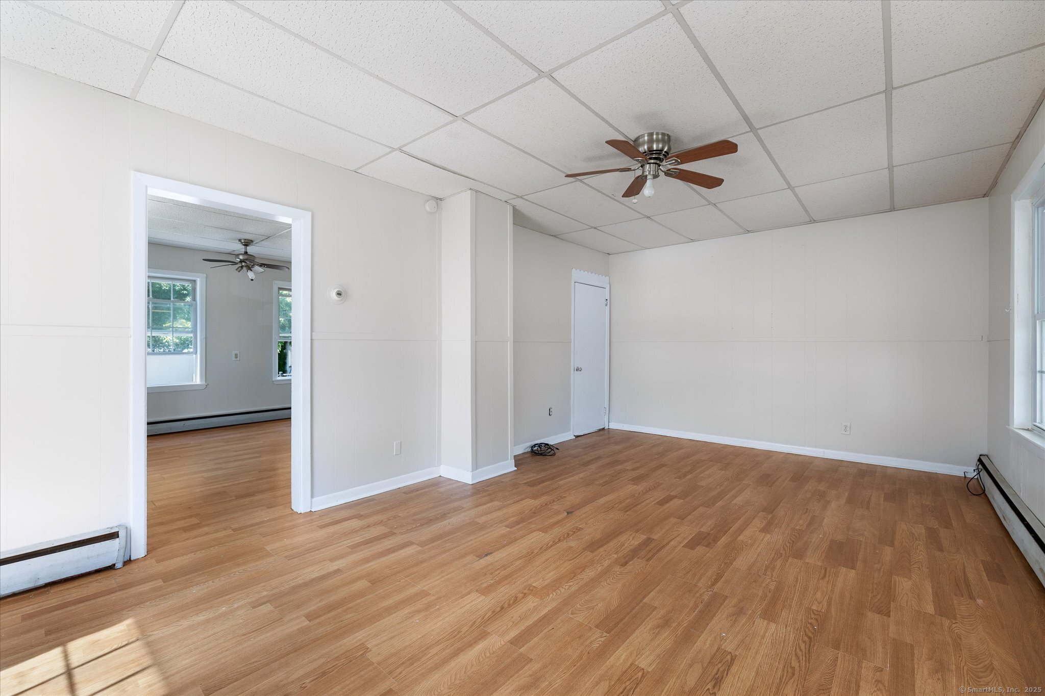 42-44 Church Street Plainfield, CT 06354 - Photo 8 of 36 an empty room with wooden floor ceiling fan and windows
