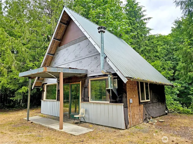 a view of house with backyard and glass windows
