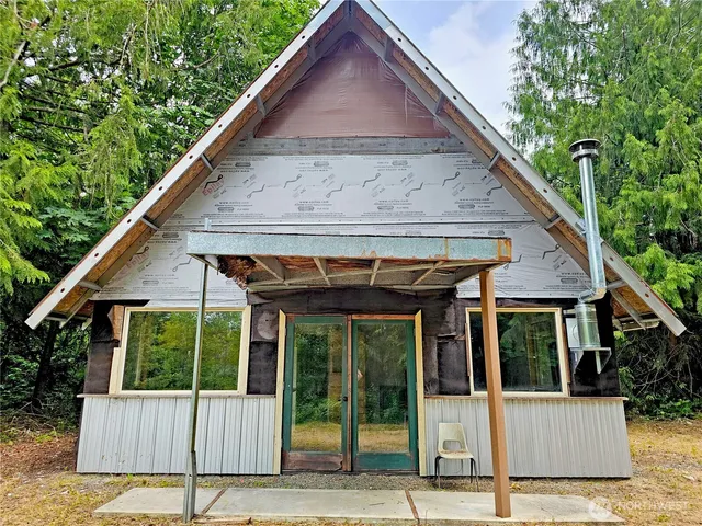 a view of a house with a small yard plants and wooden fence