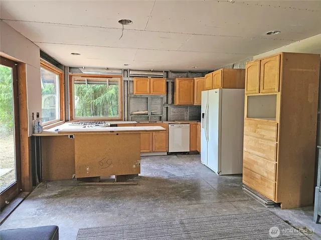 a kitchen with kitchen island a counter top space a sink stove and refrigerator