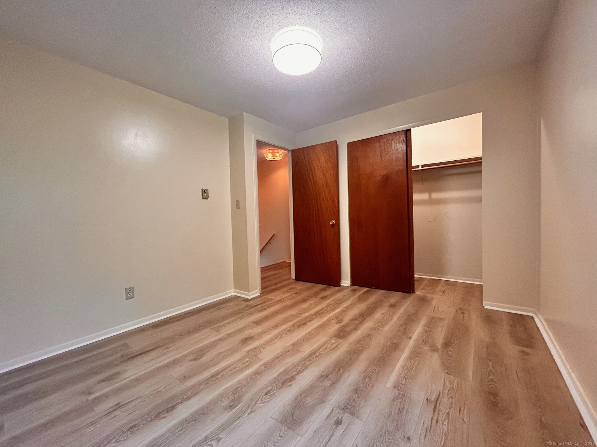 213 Baxter Road, Unit B Storrs Mansfield, CT 06268 - Photo 7 of 12 a view of an empty room with wooden floor and a window