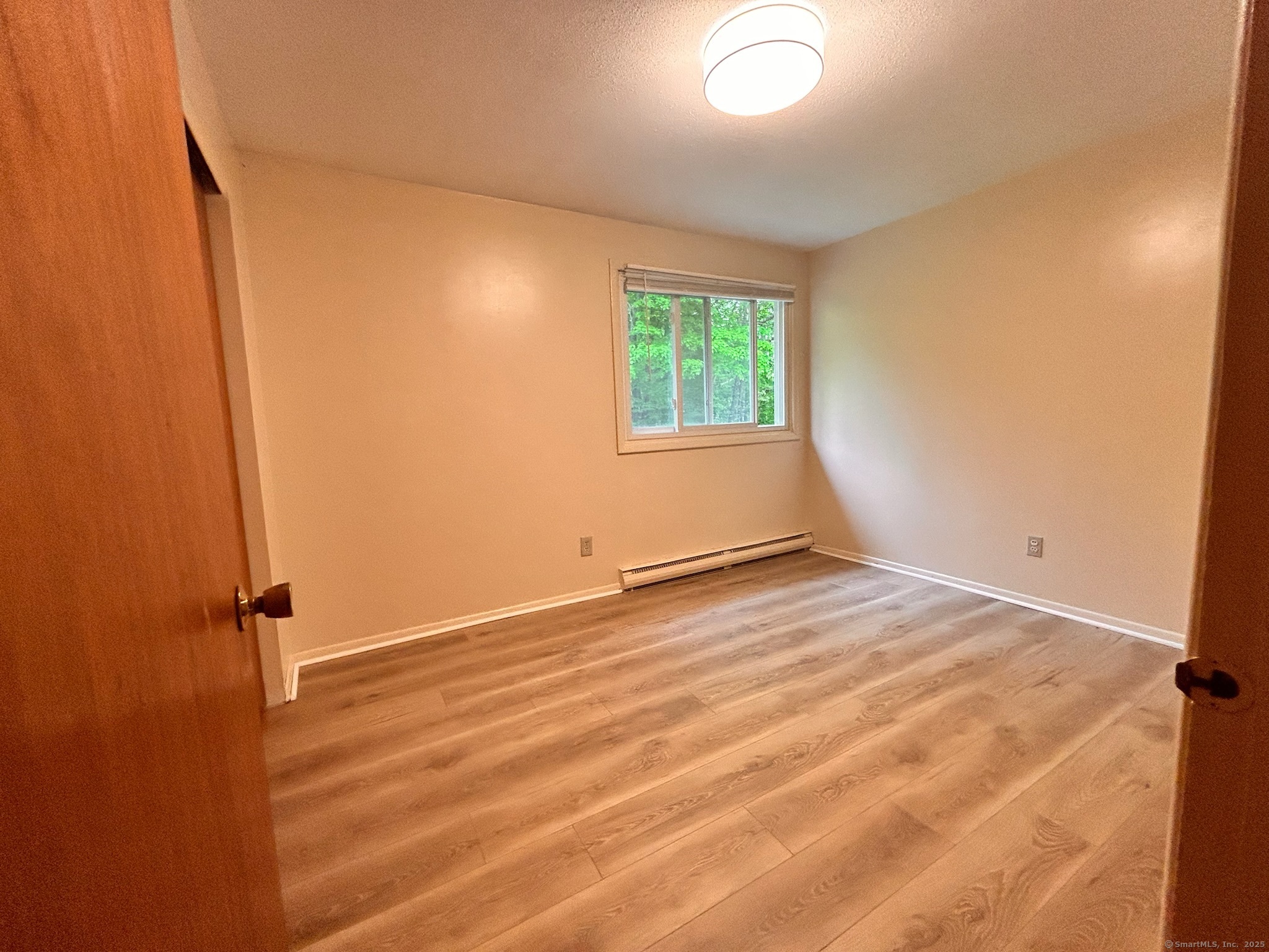 213 Baxter Road, Unit B Storrs Mansfield, CT 06268 - Photo 8 of 12 an empty room with wooden floor and windows