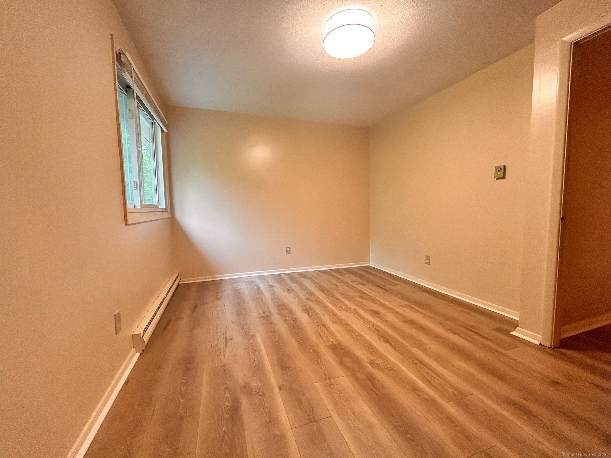 213 Baxter Road, Unit B Storrs Mansfield, CT 06268 - Photo 9 of 12 a view of empty room with wooden floor and fan