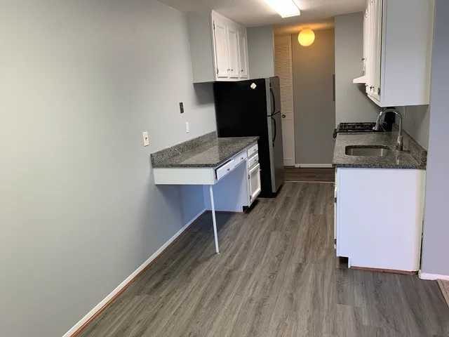 a kitchen with cabinets and wooden floor