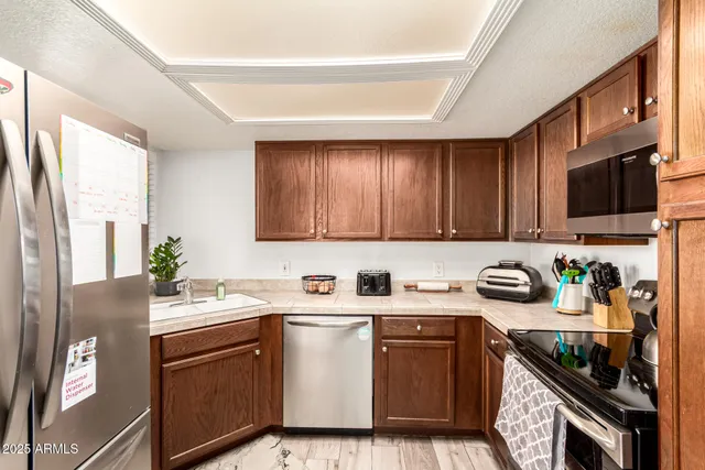 a kitchen with stainless steel appliances stove a sink dishwasher and cabinets with wooden floor