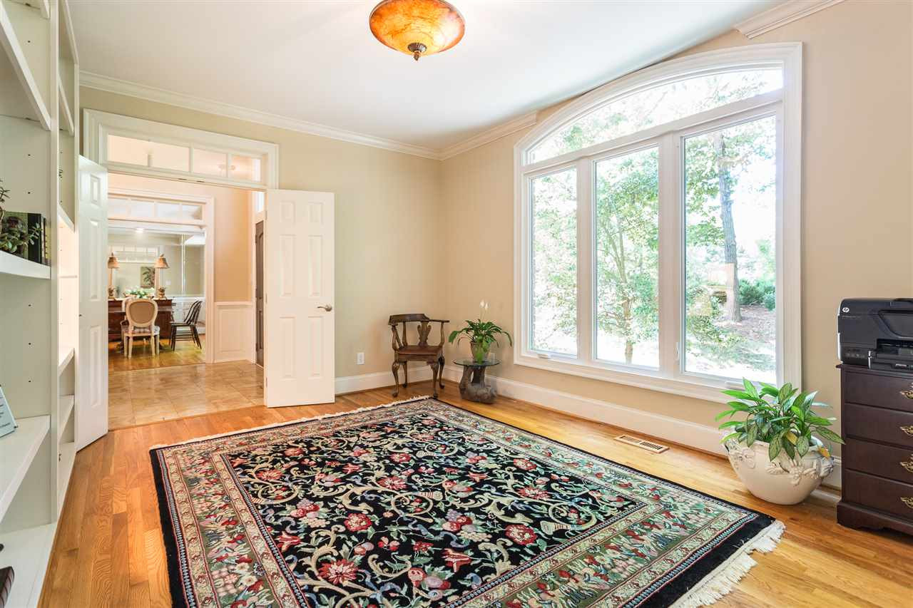 1001 Clingmans Place Raleigh, NC 27614 - Photo 5 of 30 French doors leads from the foyer to the first floor office that offers a wall of custom-built bookcases, hardwood floors, and access to the master suite. First Floor Office