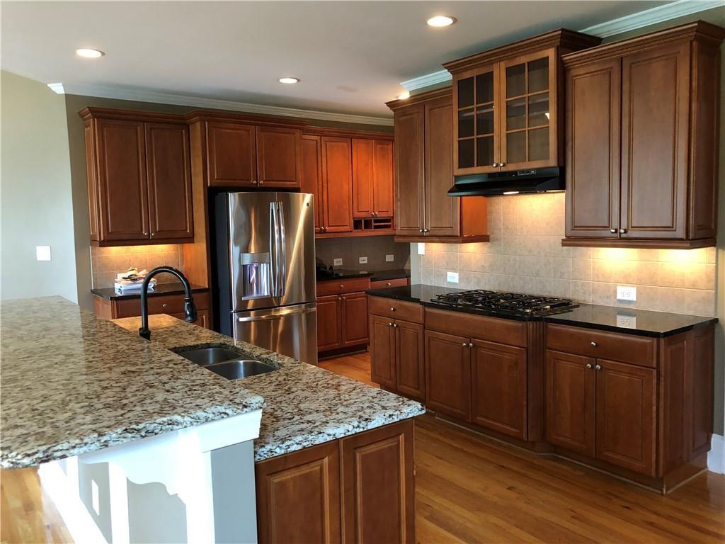 2575 Goodrick Lane Cumming, GA 30041 - Photo 11 of 30 a kitchen with stainless steel appliances granite countertop a sink refrigerator and cabinets