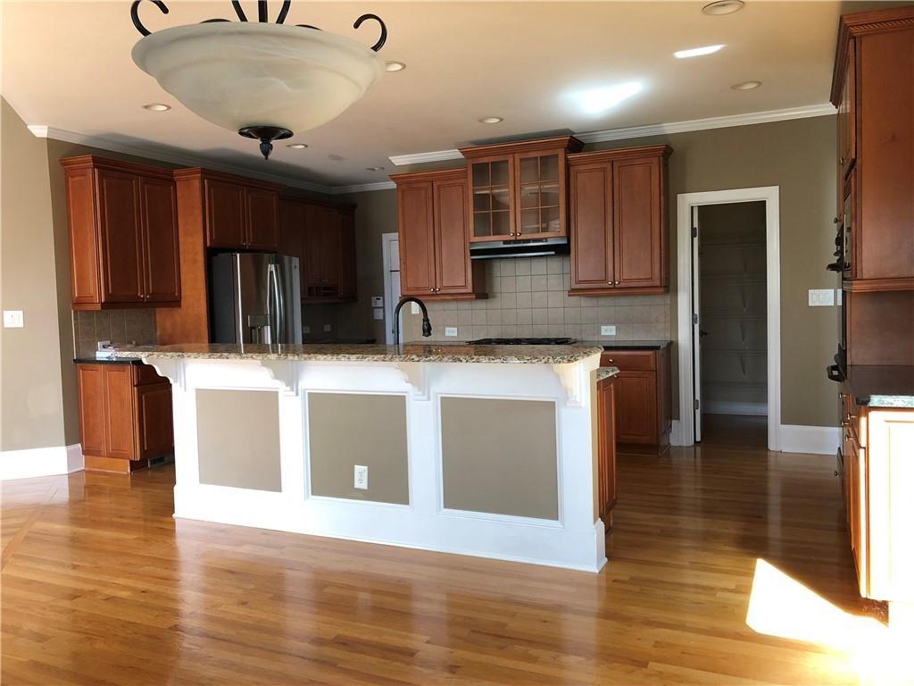 2575 Goodrick Lane Cumming, GA 30041 - Photo 12 of 30 a kitchen with stainless steel appliances granite countertop a sink a stove and a wooden floors