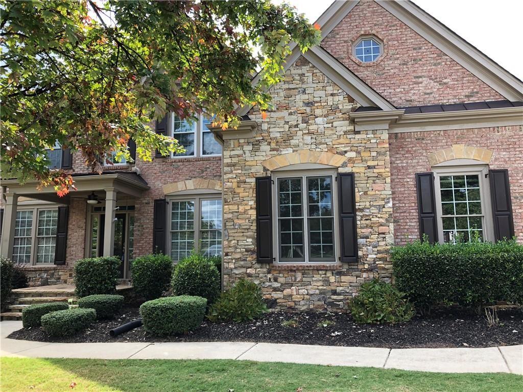2575 Goodrick Lane Cumming, GA 30041 - Photo 3 of 30 a view of a house with brick walls plants and large tree