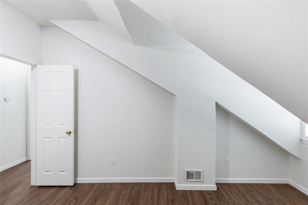 12680 Hillcrest Road, Unit 4101 Dallas, TX 75230 - Photo 9 of 37 Attic space featuring wood-finish flooring, white walls, and a multi-paneled door with brass hardware