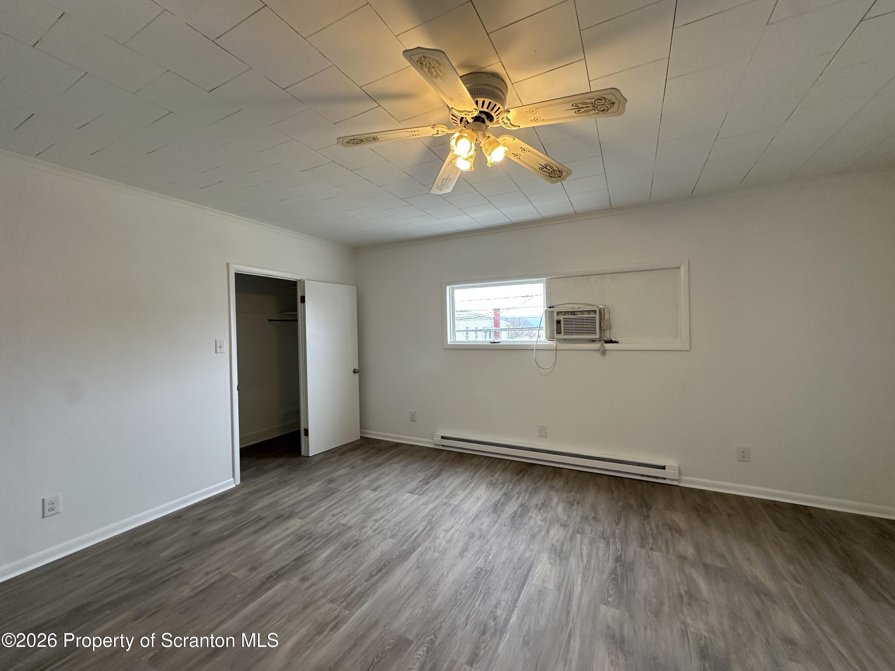 732 Main Street Avoca, PA 18641 - Photo 12 of 14 an empty room with wooden floor fan and windows