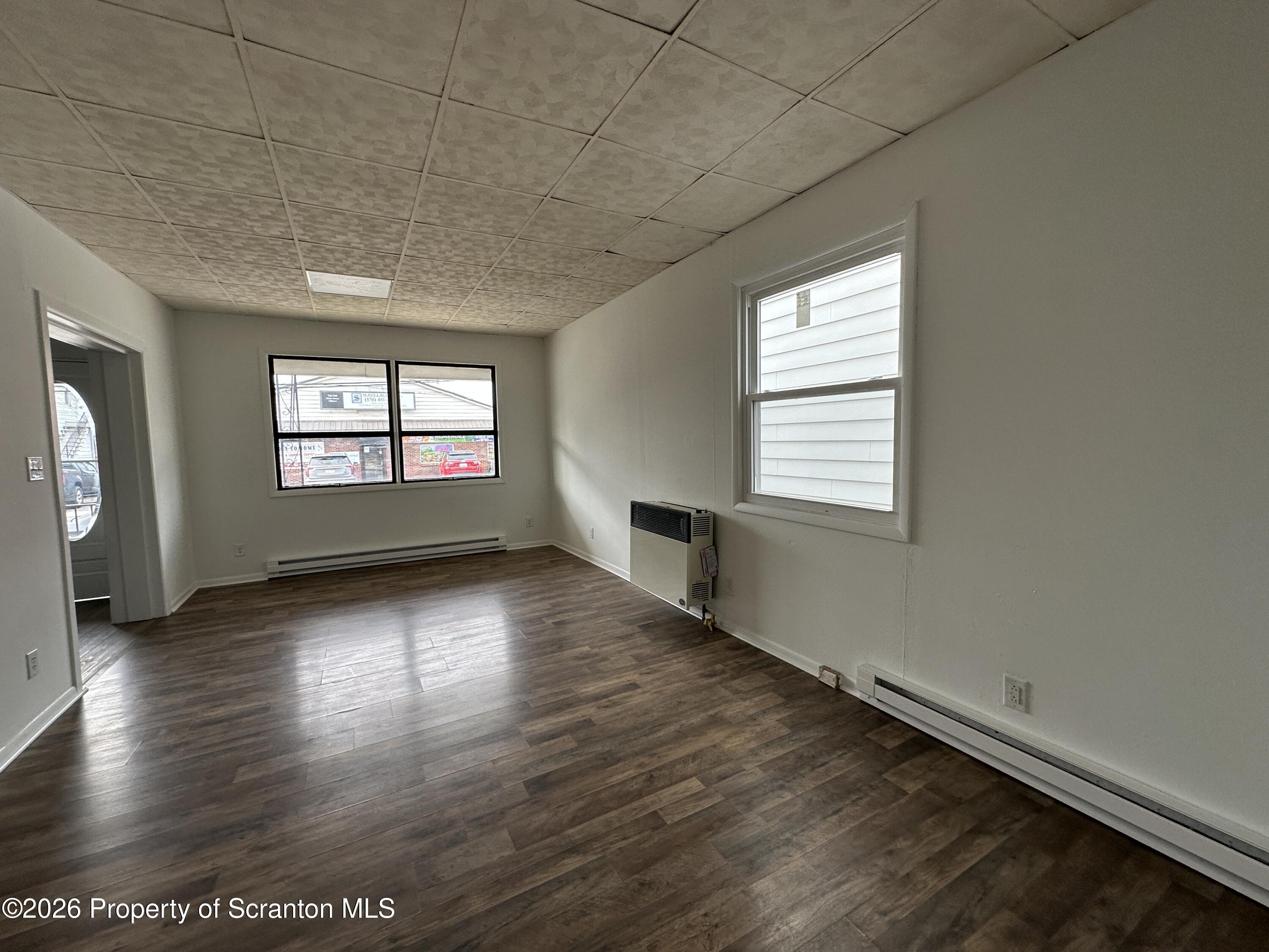 732 Main Street Avoca, PA 18641 - Photo 5 of 14 an empty room with wooden floor and windows