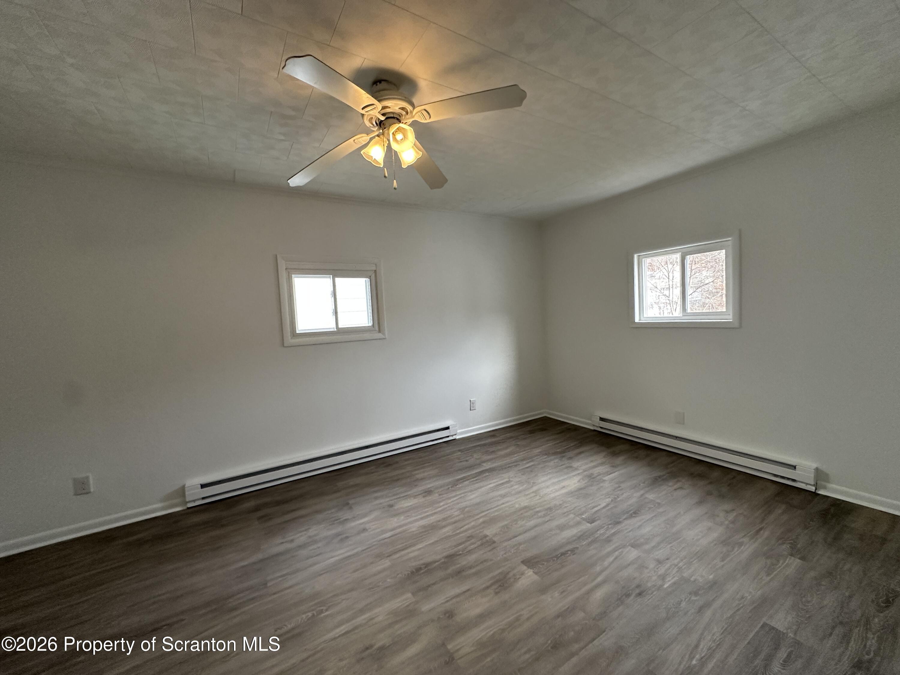 732 Main Street Avoca, PA 18641 - Photo 7 of 14 an empty room with wooden floor and windows
