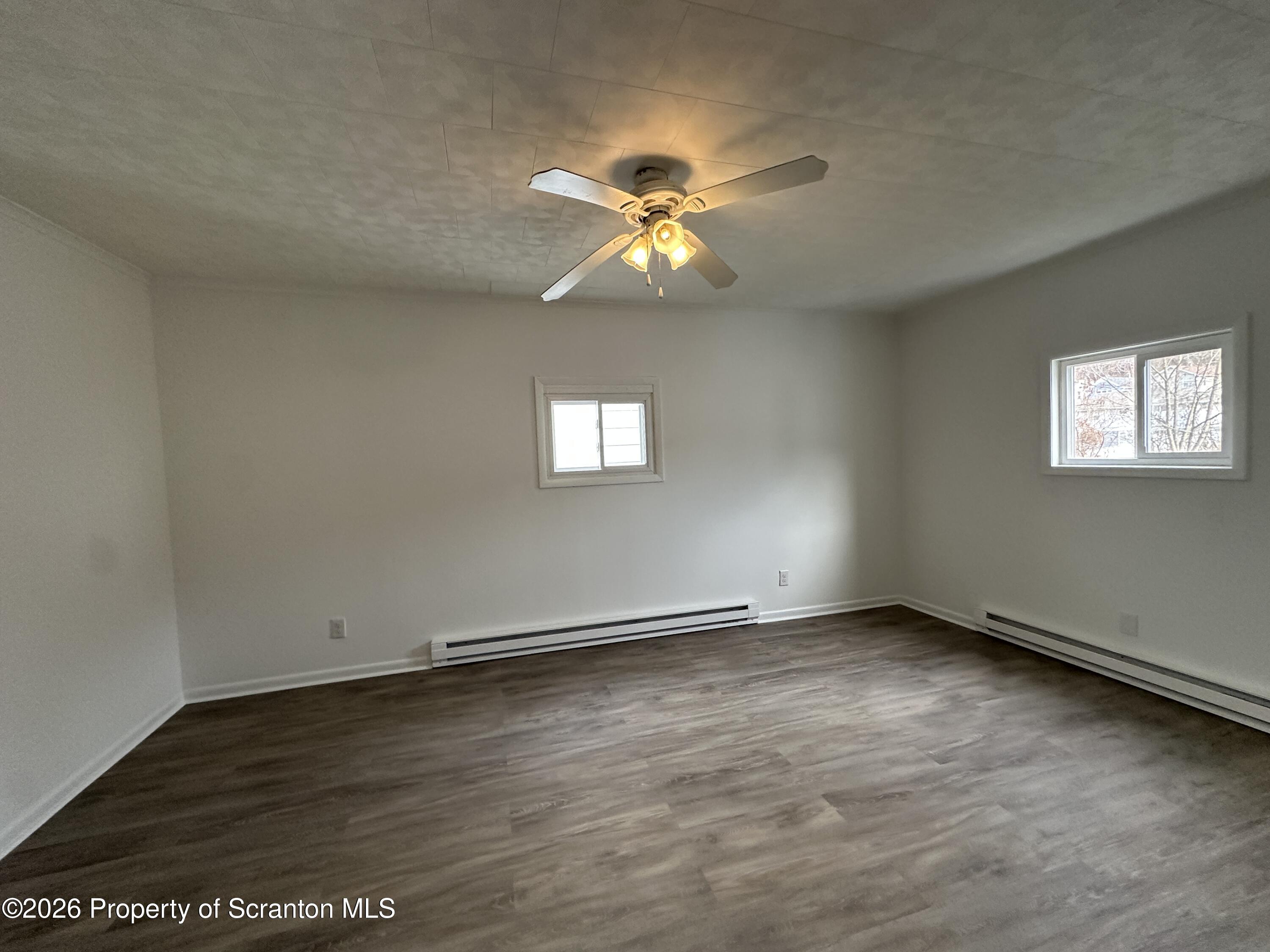 732 Main Street Avoca, PA 18641 - Photo 8 of 14 an empty room with wooden floor closet and windows
