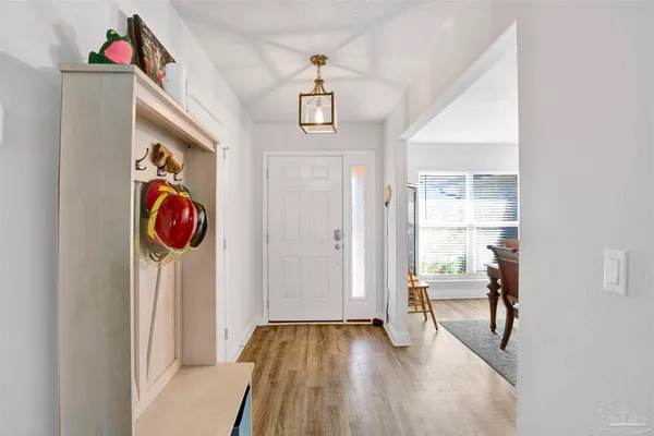 a view of a dining room with furniture a chandelier and wooden floor
