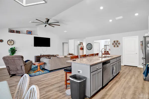 a living room with furniture a flat screen tv and wooden floor