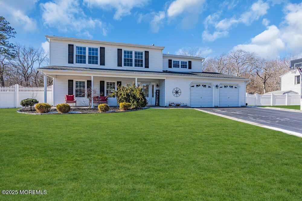 a front view of a house with a yard and trees