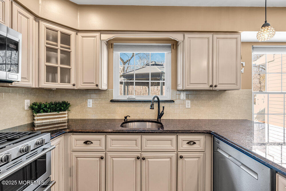 103 Starlight Road Howell, NJ 07731 - Photo 13 of 37 a kitchen with stainless steel appliances granite countertop a sink a stove and cabinets