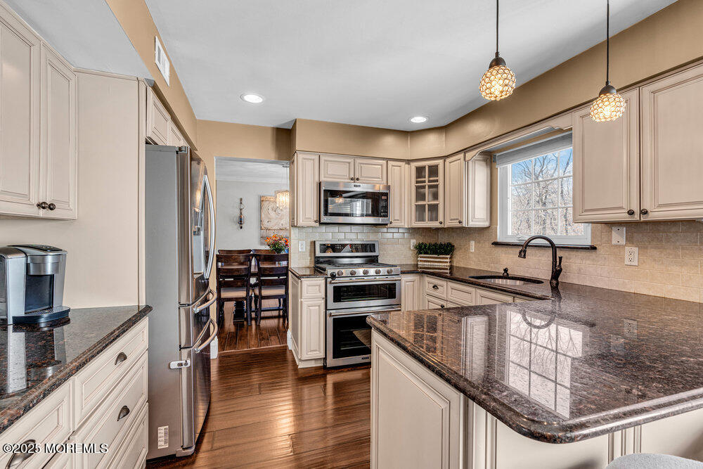 103 Starlight Road Howell, NJ 07731 - Photo 14 of 37 a kitchen with stainless steel appliances granite countertop a stove top oven a sink dishwasher a refrigerator and cabinets with wooden floor