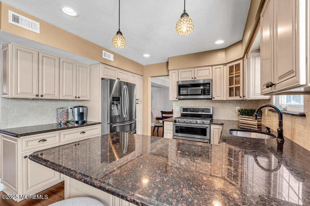 103 Starlight Road Howell, NJ 07731 - Photo 15 of 37 a kitchen with stainless steel appliances granite countertop a stove microwave and refrigerator