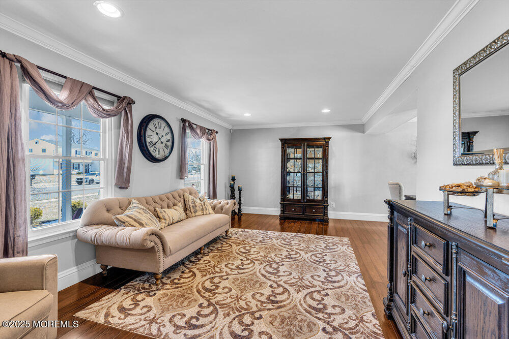 103 Starlight Road Howell, NJ 07731 - Photo 6 of 37 a living room with furniture a clock on wall and a window